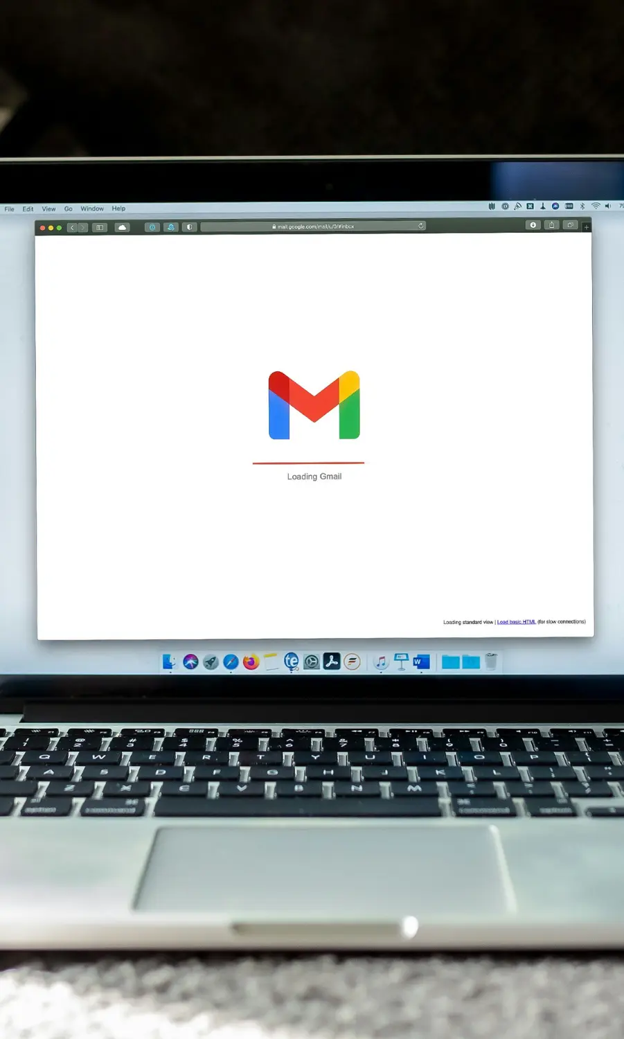 MacBook laptop screen loading Gmail, representing professional email marketing campaigns and automated sales flows.